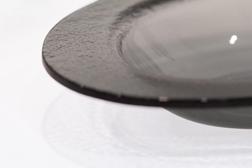 Ces assiettes pensée pour la dégustation des moules évoquent l’ouverture du coquillage. La cloche protectrice à l’arrivée, devient récipient pour les coquilles vides.