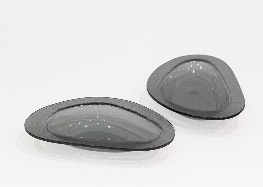 Ces assiettes pensée pour la dégustation des moules évoquent l’ouverture du coquillage. La cloche protectrice à l’arrivée, devient récipient pour les coquilles vides.